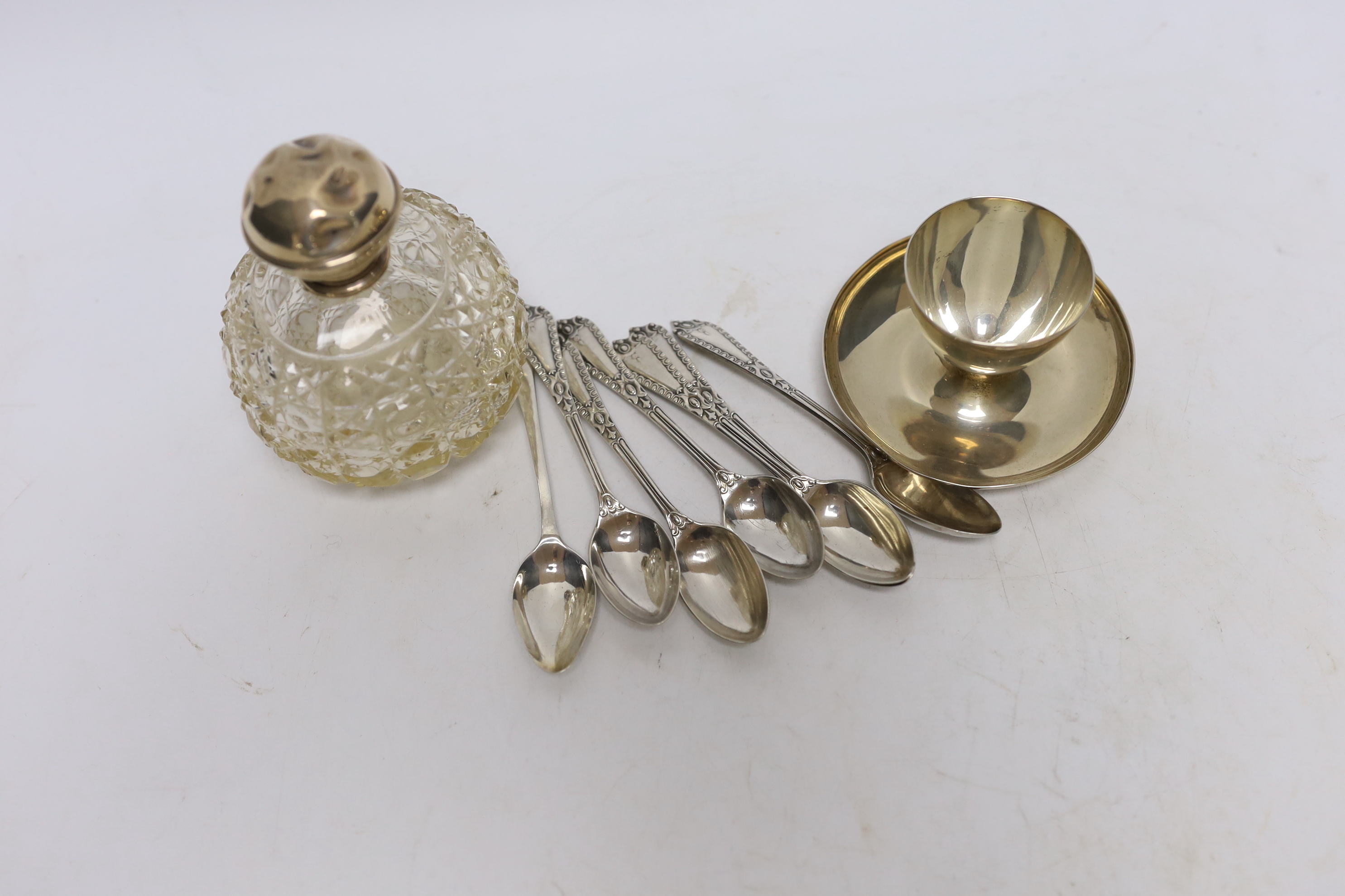 A set of six George V silver coffee spoons, Goldsmiths & Silversmiths Co Ltd, London, 1910, a similar silver Old English pattern coffee spoon, a silver egg cup and silver mounted glass toilet jar.